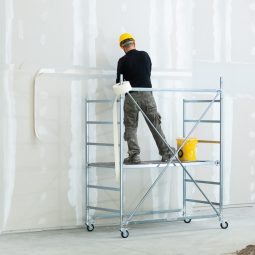 Interior construction, worker plastering gypsum board wall.